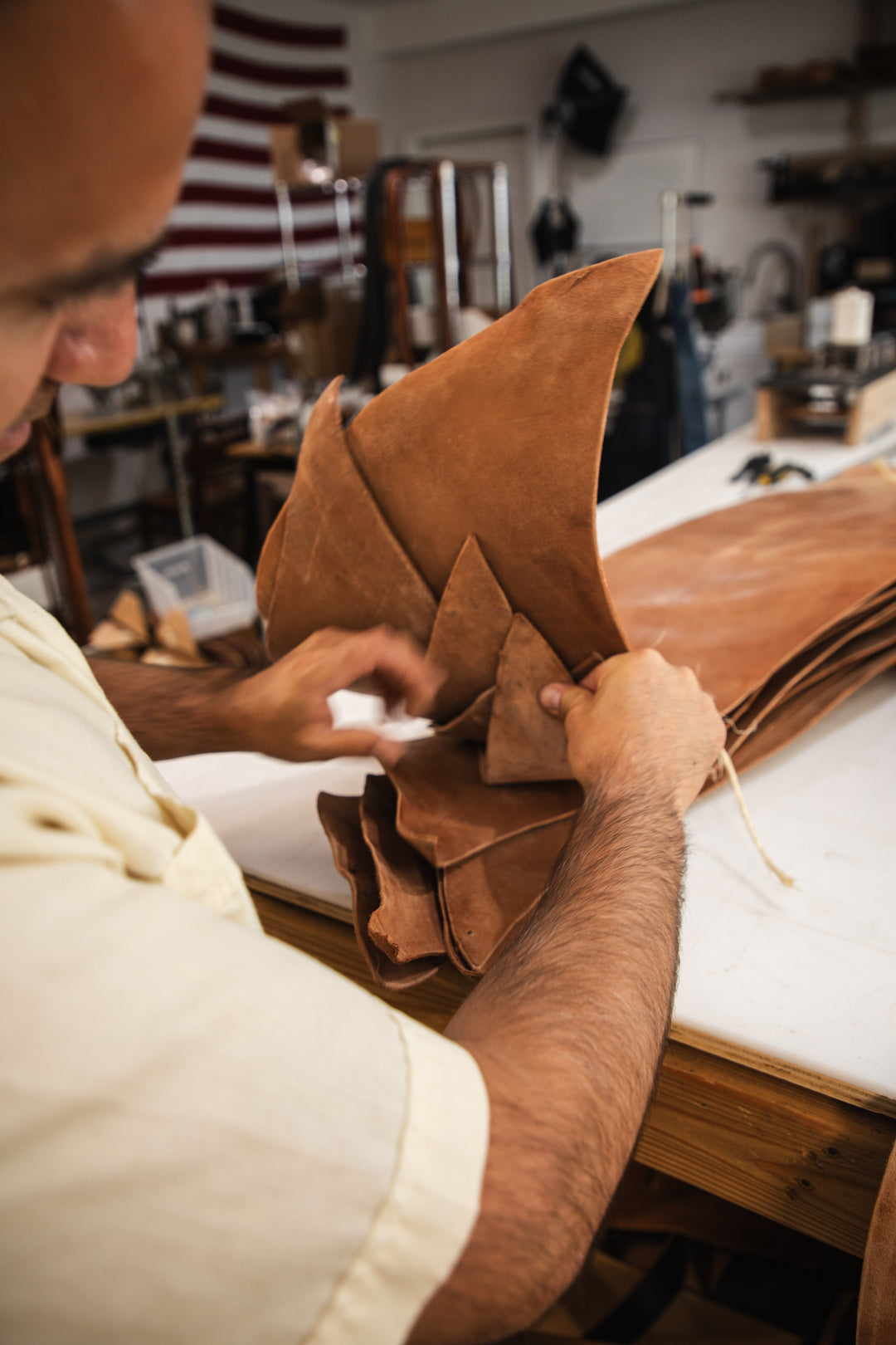 Russet horsehide belt lifestyle sorting hides on table