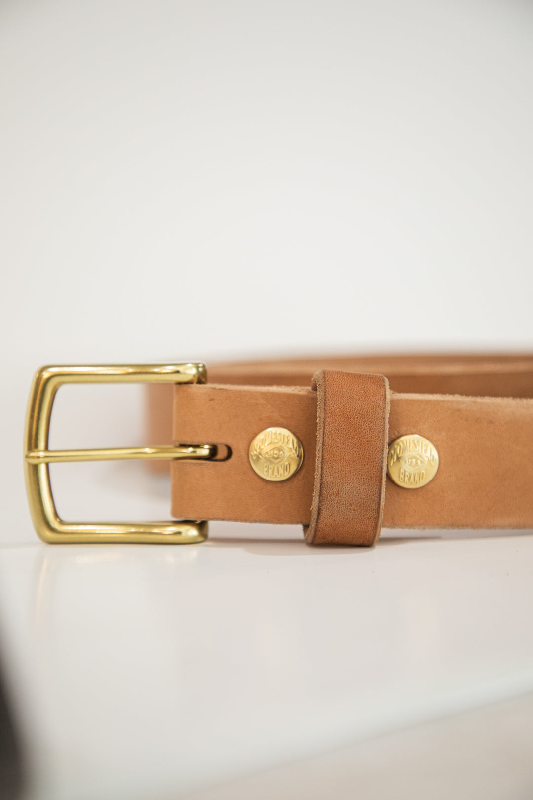 Russet horsehide belt buckle on table on side