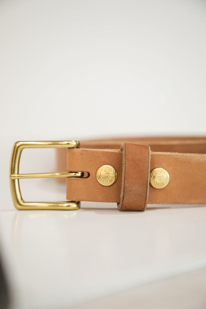 Russet horsehide belt buckle on table on side