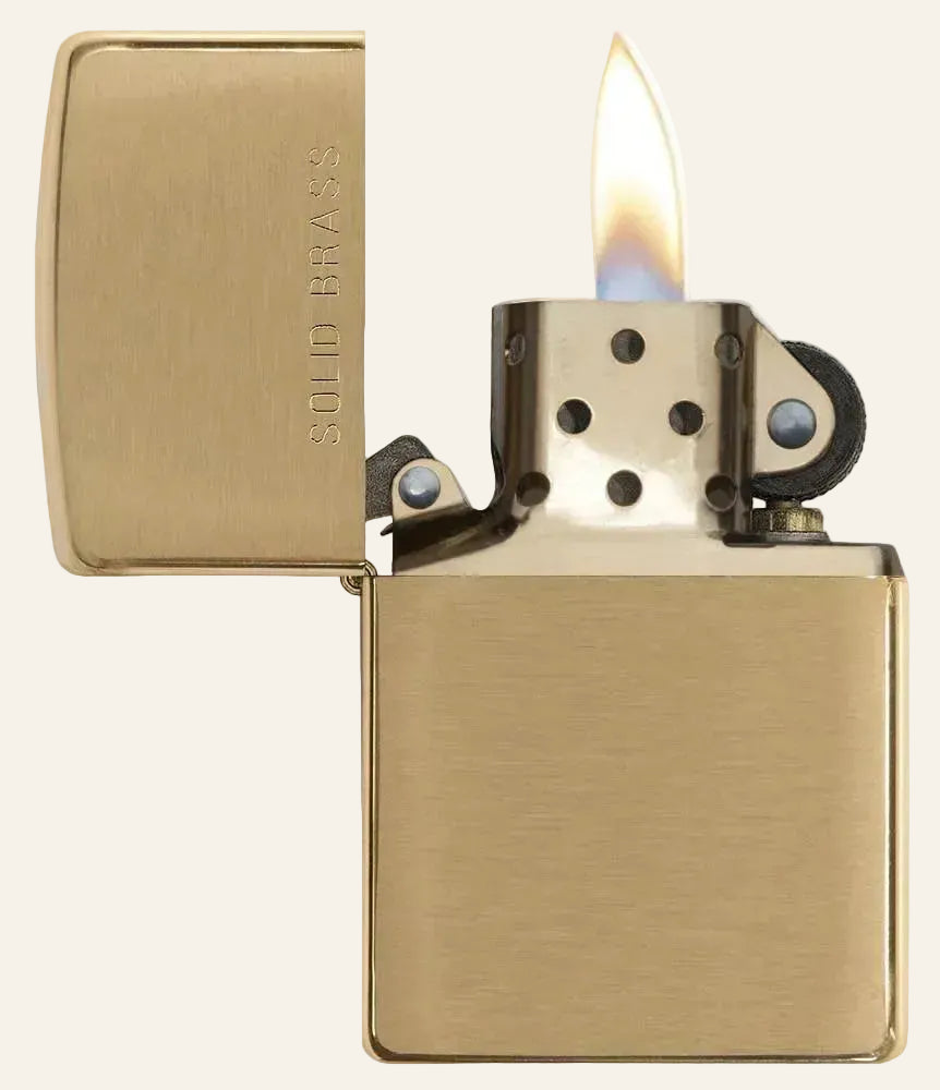 brass zippo lighter with flame exposed 
