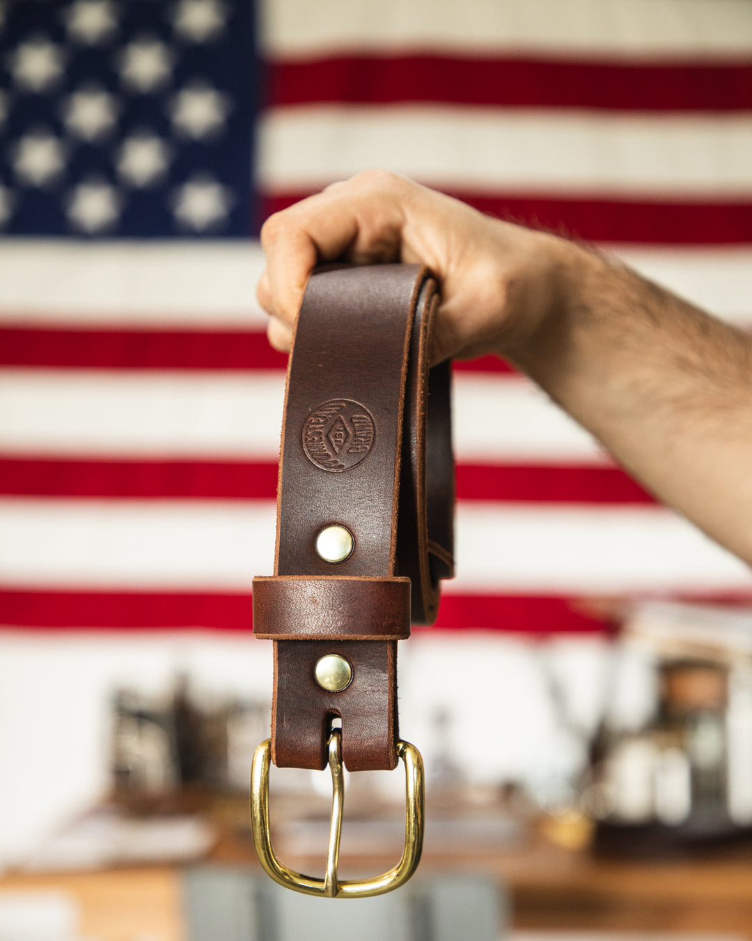 Brown Belt Riveted Held in Hand in Front of American Flag #color_brown