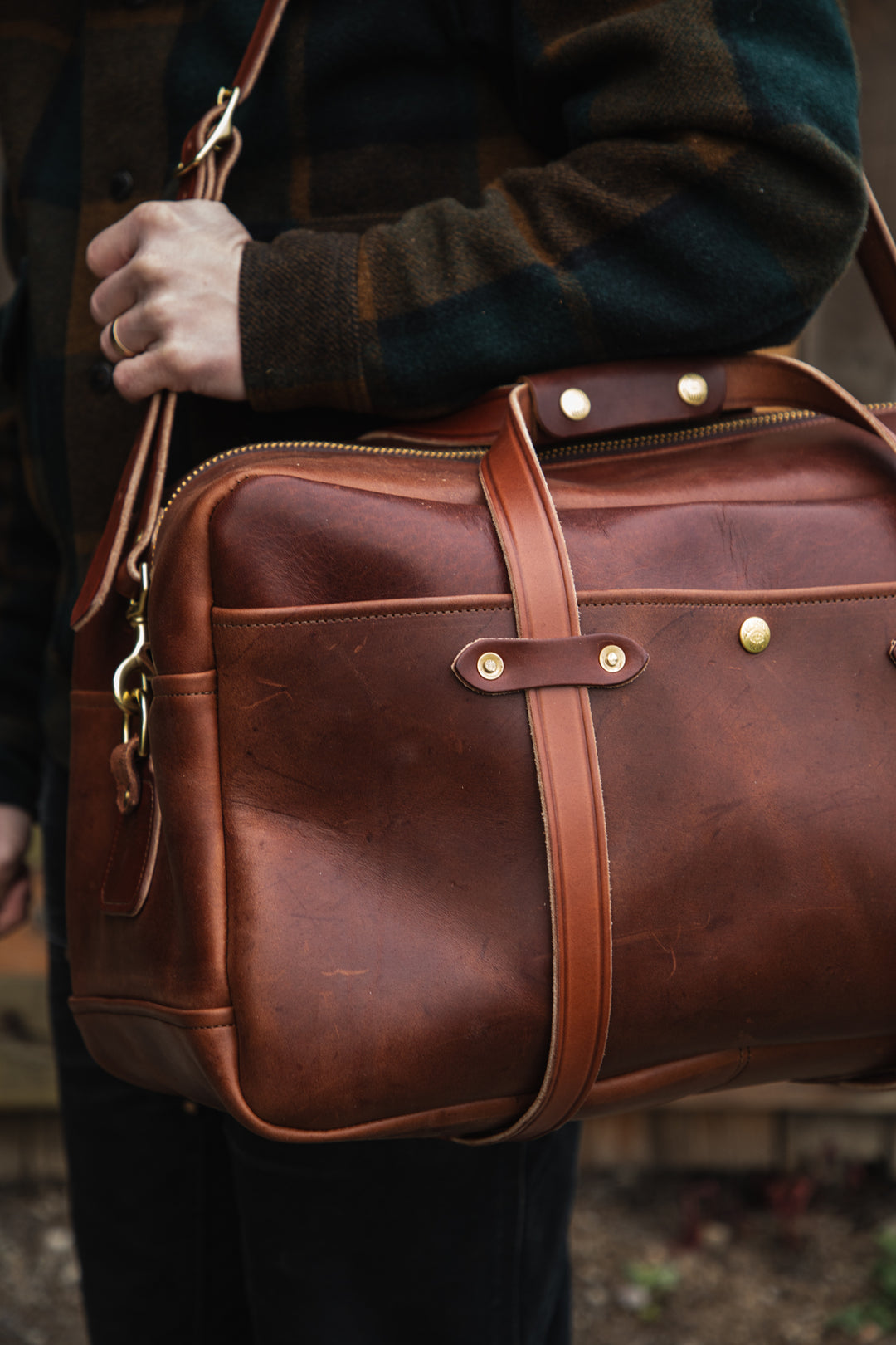 mens brown duffle bag front corner on person #color_brown