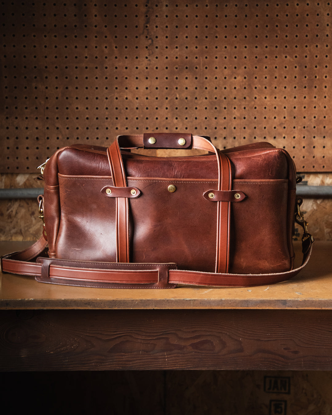 brown duffle on workbench side view #color_brown