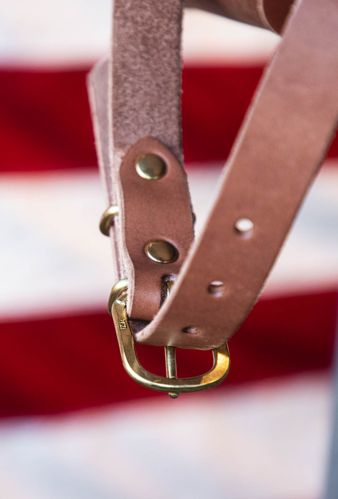 leather shoulder strap on brown leather duffle bag 