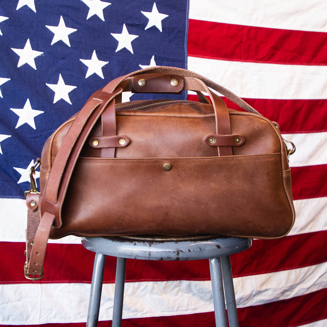 USA MADE Brown Duffle Bag in front of flag 