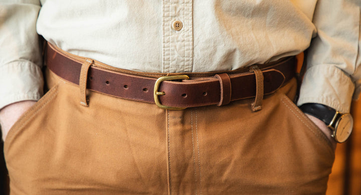 Close-up of a person wearing a brown belt with a gold buckle and white shirt #color_brown