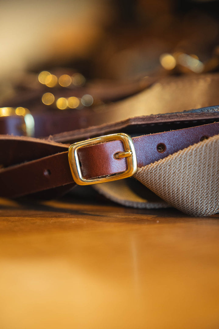 Brown belt with a gold buckle on a wooden surface